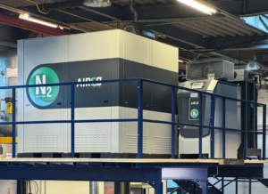 In der Mitte des Bildes ist die Valenta Metall Stickstoff Anlage auf einem Zwischenstockwerk in einer Halle mit einer Decke aus Metallkonstruktion