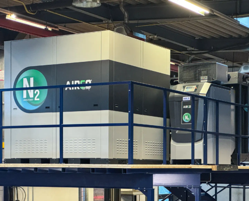 In der Mitte des Bildes ist die Valenta Metall Stickstoff Anlage auf einem Zwischenstockwerk in einer Halle mit einer Decke aus Metallkonstruktion